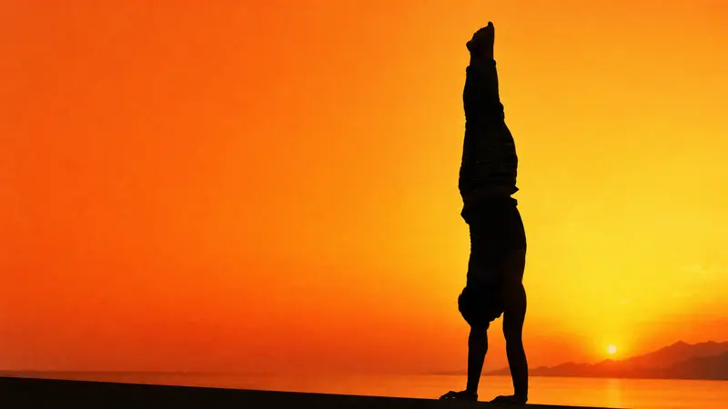 Handstand silhouette rendered in saffron